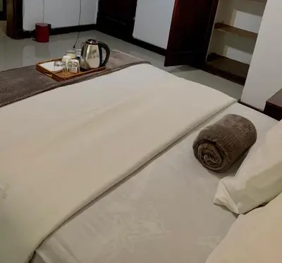 a white bed with a tray on top of it at Khaya Mnandi Leisure Suites in Pretoria