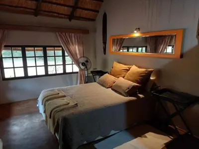 a bedroom with a bed and a mirror on the wall at Tumuga Private Cottage Mokopane in Amatava