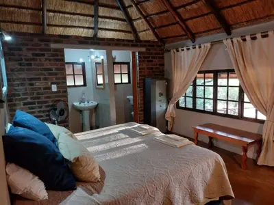 a bedroom with a bed and a brick wall at Tumuga Private Cottage Mokopane in Amatava