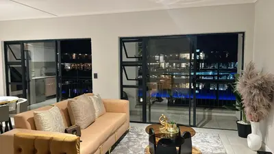 a living room with a couch and large windows at The Blyde Crystal Lagoon Luxury Stays in Pretoria