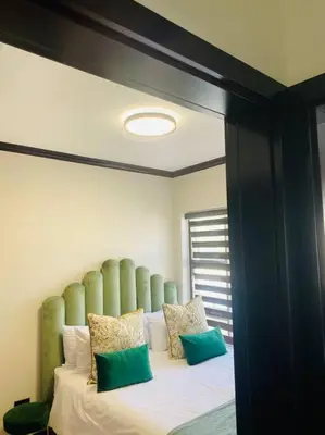 a bed with a green headboard in a room at LuxuryHome in Midrand