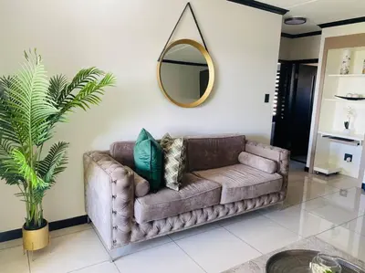 a brown couch in a living room with a mirror at LuxuryHome in Midrand