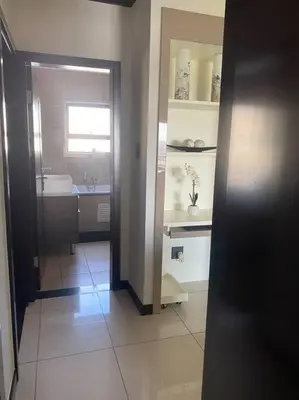 a hallway of a bathroom with a sink and a mirror at LuxuryHome in Midrand