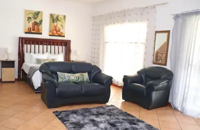a living room with two chairs and a bed at Umnotho We Afrika House in Erasmus