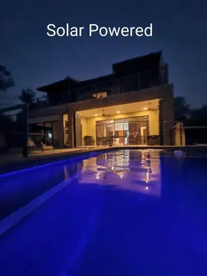 a swimming pool in front of a house at night at Rosendal Kruger View Villa in Marloth Park