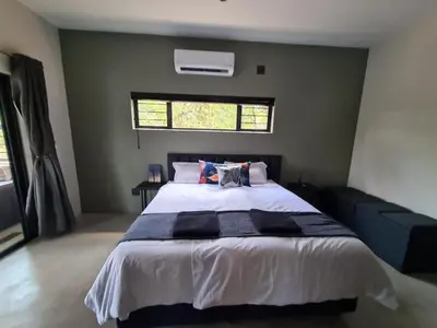 a bedroom with a large bed and a window at Rosendal Kruger View Villa in Marloth Park