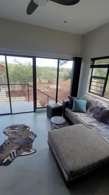 a living room with a couch and a large window at Rosendal Kruger View Villa in Marloth Park