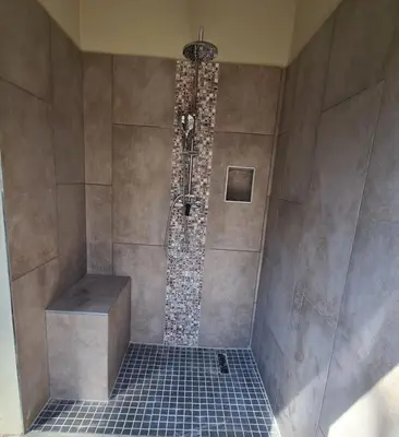 a shower in a bathroom with a tiled floor at Rosendal Kruger View Villa in Marloth Park