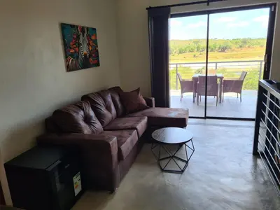 a living room with a brown couch and a table at Rosendal Kruger View Villa in Marloth Park