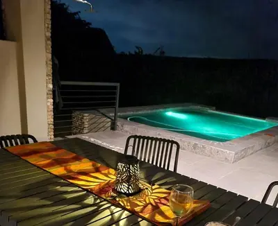 a table with a glass of wine on top of a table with a pool at Rosendal Kruger View Villa in Marloth Park