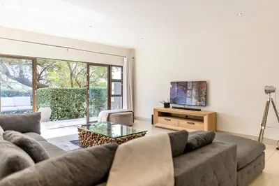 a living room with a couch and a television at Modern 5BR Villa - Golf Course - Pecanwood Estate in Hartbeespoort
