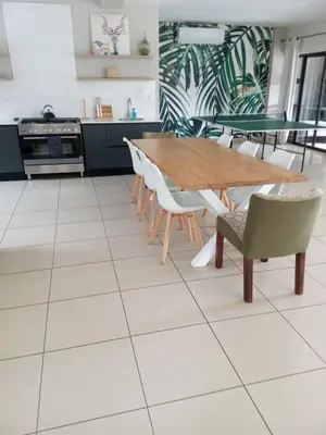 a kitchen with a wooden table and chairs at Modern 5BR Villa - Golf Course - Pecanwood Estate in Hartbeespoort