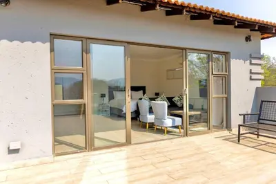a patio with sliding glass doors on a house at Modern 5BR Villa - Golf Course - Pecanwood Estate in Hartbeespoort