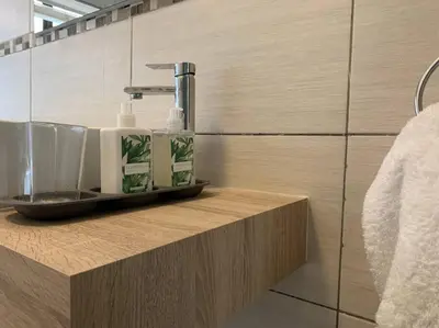 a bathroom with a sink with two soap bottles on a counter at Modern 5BR Villa - Golf Course - Pecanwood Estate in Hartbeespoort