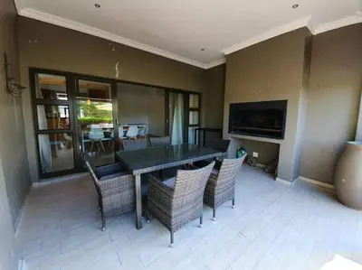 a dining room with a table and chairs at Modern 5BR Villa - Golf Course - Pecanwood Estate in Hartbeespoort