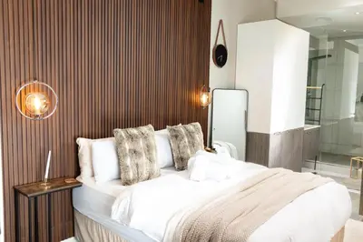 a bedroom with a large white bed and a mirror at Menlyn Maine Luxury Apartments - Penthouse 1217 in Pretoria