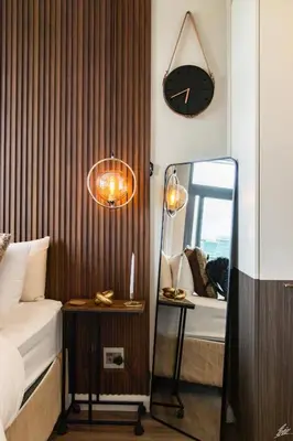 a bedroom with a mirror and a clock on the wall at Menlyn Maine Luxury Apartments - Penthouse 1217 in Pretoria