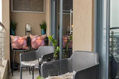 a balcony with chairs and tables on a building at Menlyn Maine Luxury Apartments - Penthouse 1217 in Pretoria