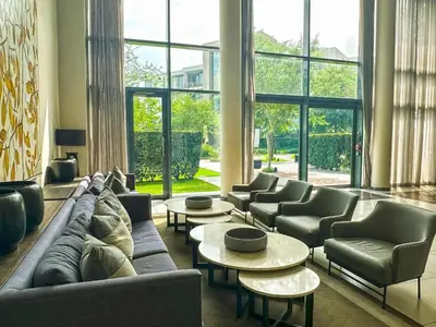 a living room with couches and tables and windows at Menlyn Maine Luxury Apartments - Penthouse 1217 in Pretoria