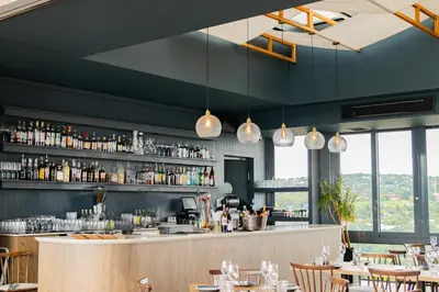 a restaurant with a bar with tables and chairs at Menlyn Maine Luxury Apartments - Penthouse 1217 in Pretoria