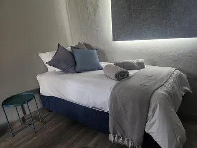 a bed with pillows on it in a room at @241 Enkeldoorn Guesthouse in Pretoria