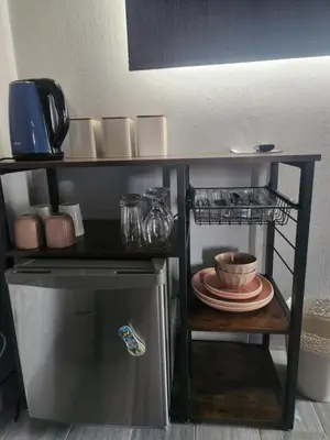 a small kitchen with a shelf above a small refrigerator at @241 Enkeldoorn Guesthouse in Pretoria