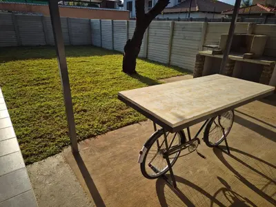 a picnic table sitting on a patio in a yard at @241 Enkeldoorn Guesthouse in Pretoria