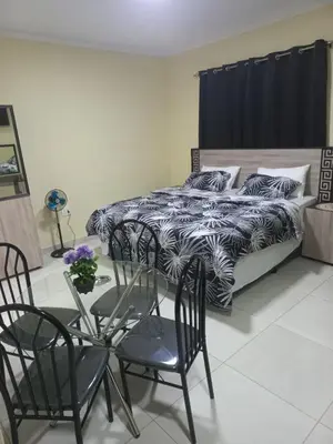 a bedroom with a bed and a table and chairs at First derby Lodge in Benoni