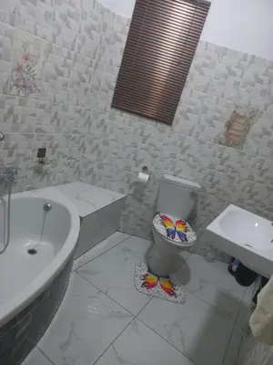 a white bathroom with a toilet and a sink at First derby Lodge in Benoni