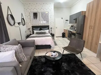 a living room with a bed and a couch at Greencreek Riverwalk in Pretoria
