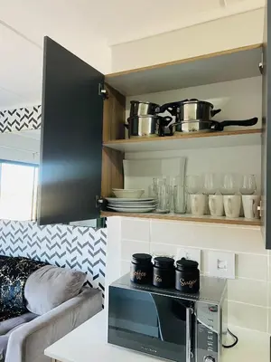 a kitchen with a microwave oven with pots and pans at Greencreek Riverwalk in Pretoria
