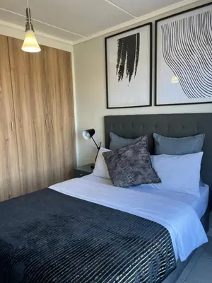 a bedroom with a large bed with two pillows at Greencreek Riverwalk in Pretoria