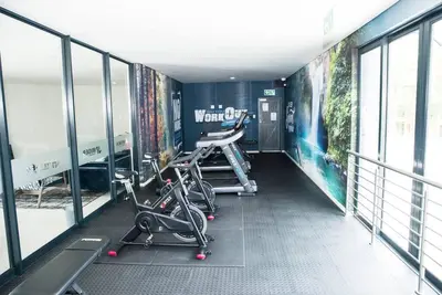 a gym with bikes parked in a room with windows at The Ellipse Palazzo Apartment in Midrand