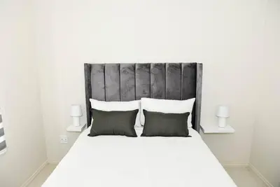 a bedroom with a large white bed with two pillows at The Ellipse Palazzo Apartment in Midrand