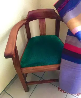 a wooden chair with a green seat next to a bed at White Rose Cozy Apartment in Midrand