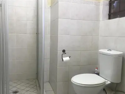 a bathroom with a toilet and a shower at White Rose Cozy Apartment in Midrand