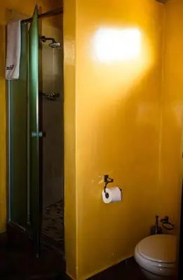 a yellow bathroom with a toilet and a shower at Africa Self Catering Chalets - Manyeleti in Manyeleti Game Reserve