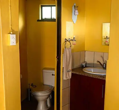 a yellow bathroom with a toilet and a sink at Africa Self Catering Chalets - Manyeleti in Manyeleti Game Reserve
