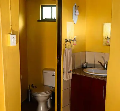 a yellow bathroom with a toilet and a sink at Africa Self Catering Chalets - Manyeleti in Manyeleti Game Reserve