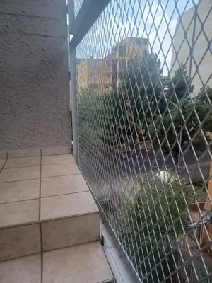 a fence on a balcony with a view of a city at Beyond Comfort Apartment in Pretoria