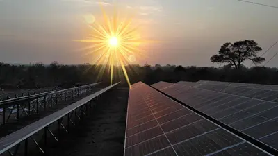 a sun shines over solar panels in a field at Inyati Game Lodge in Sabi Sand Game Reserve