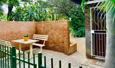 a patio with a table and chairs and a fence at Cozy Corner in Groblersdal