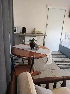 a table and chairs in a small room with a table at Cozy Corner in Groblersdal