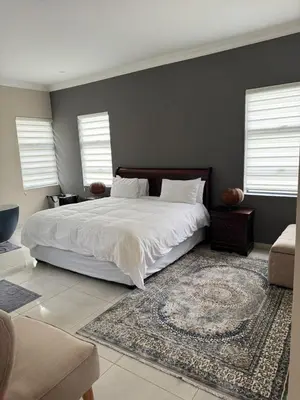 a bedroom with a large white bed and a rug at The 314 Euphoria Golf Estate in Naboomspruit