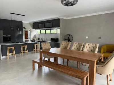 a kitchen and living room with a wooden table and chairs at The 314 Euphoria Golf Estate in Naboomspruit