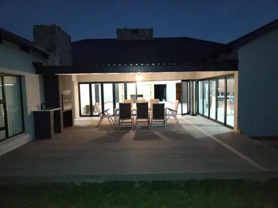 a patio with a table and chairs on it at night at The 314 Euphoria Golf Estate in Naboomspruit