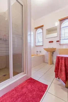 a bathroom with a shower and a sink at Bay Tree Guest House in Pretoria