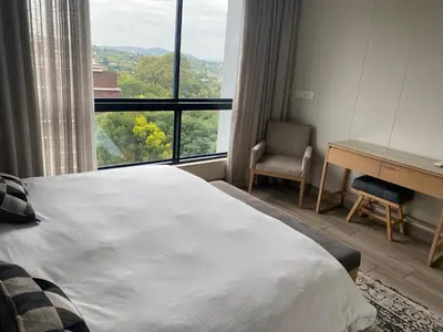 a bedroom with a bed and a desk and a window at Luxurious 2 bedroom @ The Regency Hotel in Pretoria
