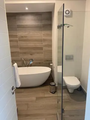 a bathroom with a bath tub and a toilet at Luxurious 2 bedroom @ The Regency Hotel in Pretoria