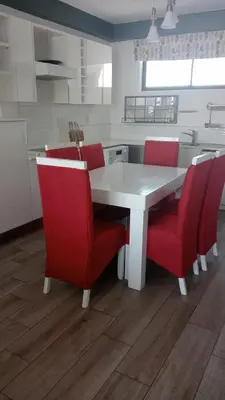 a kitchen with a white table and red chairs at Luxurious 2 bedroom @ The Regency Hotel in Pretoria